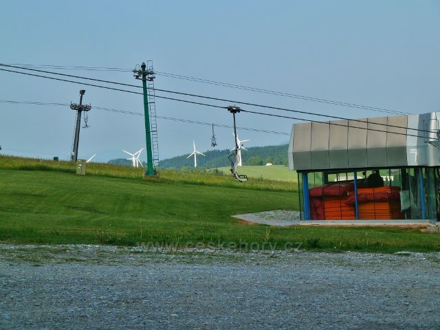Ramzová - část areálu lanovky na Šerák, v pozadí  vykukují větrné elektrárny v Ostružné