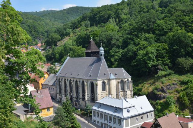 Kostel Nanebevzetí Panny Marie.v pozadí dřevěná zvonice