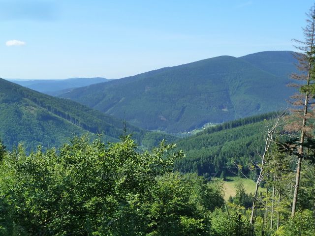 Pohled z cesty po červené TZ z Butořanky na Lukšinec do údolí Mazáku a Ostravice. Vpravo je Malý Smrk a Smrk