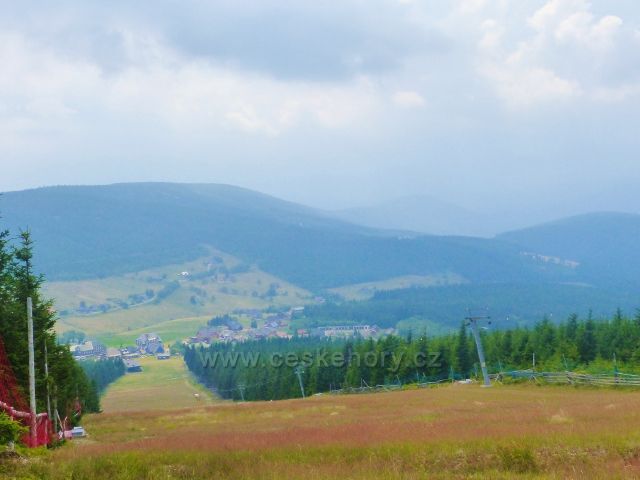 Pohled na sjezdovku skiareálu Pomezní boudy a Horní Malou Úpu.Nad údolím vystupuje Hraniční hřeben