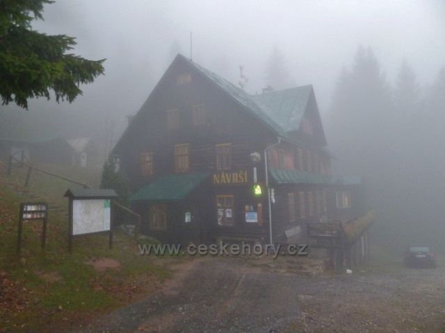 Králický Sněžník - horská chata Návrší nad obcí Stříbrnice v podzimním šeru a obklopena mlhou