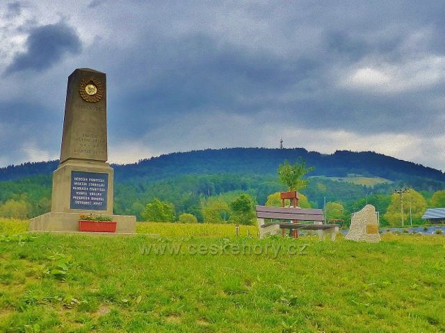 Památník obětem 1.Světové války v obci Loktuše(v pozadí je vrch Kozákov s rozhlednou)