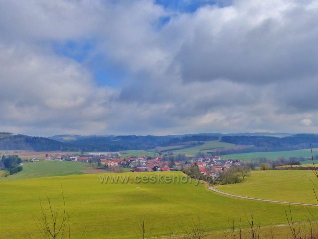 Pohled z návrší Homol k vykukující na obzoru 4 km vzdálené vzdušnou čarou Kapraď (529 m.n.m.)