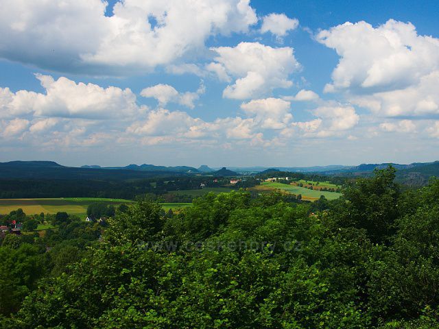 Výhled z rozhledny Růženka na Pastevním vrchu. Uprostřed obec Janov, za ní výrazné vrcholy Zirkelstein a Lilienstein.